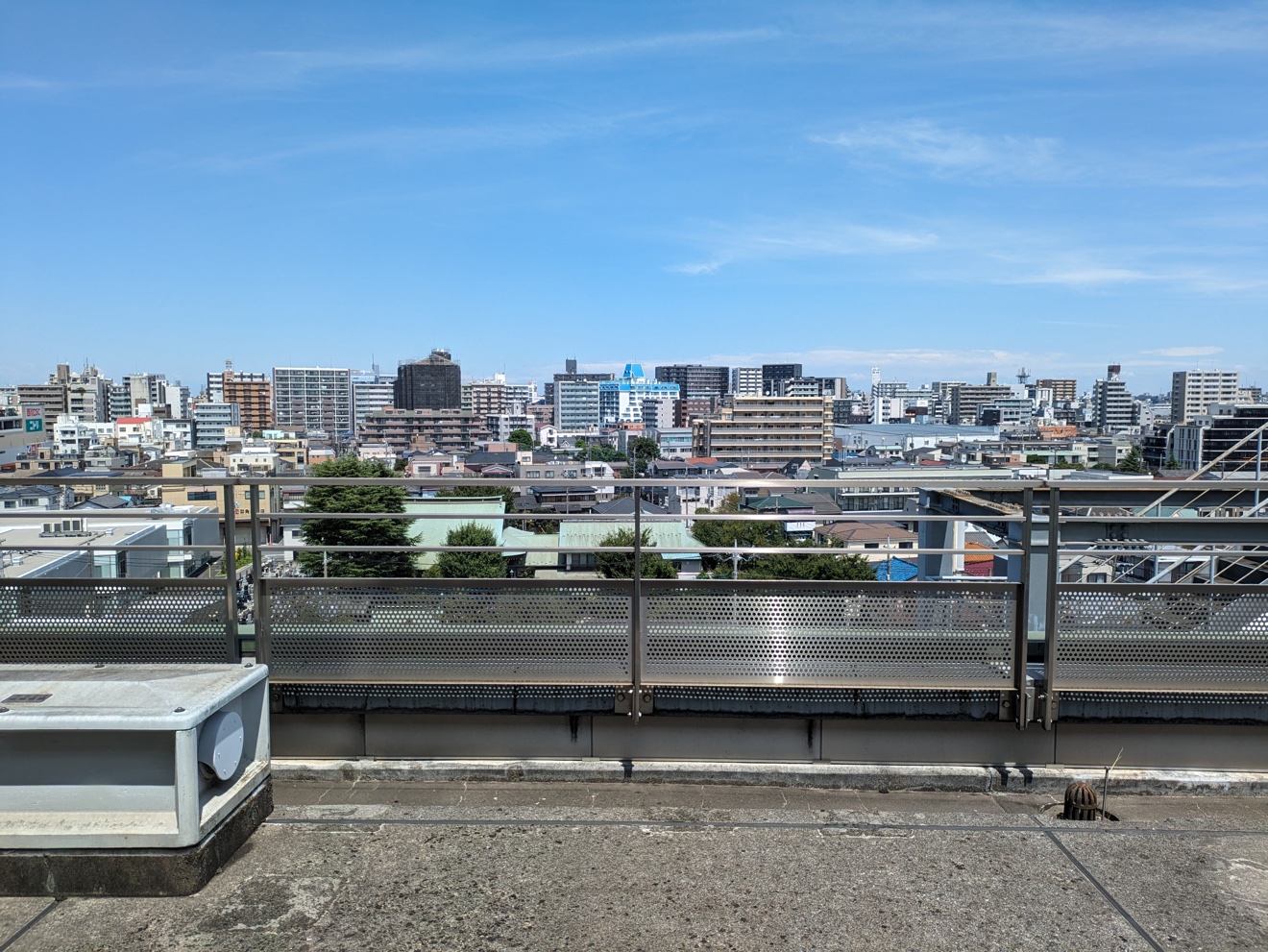 青空の下、屋上から望む川口の街並み。マンションや住宅が広がる